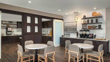 A modern kitchen with dark wood cabinets, white countertops, and a central island with seating.