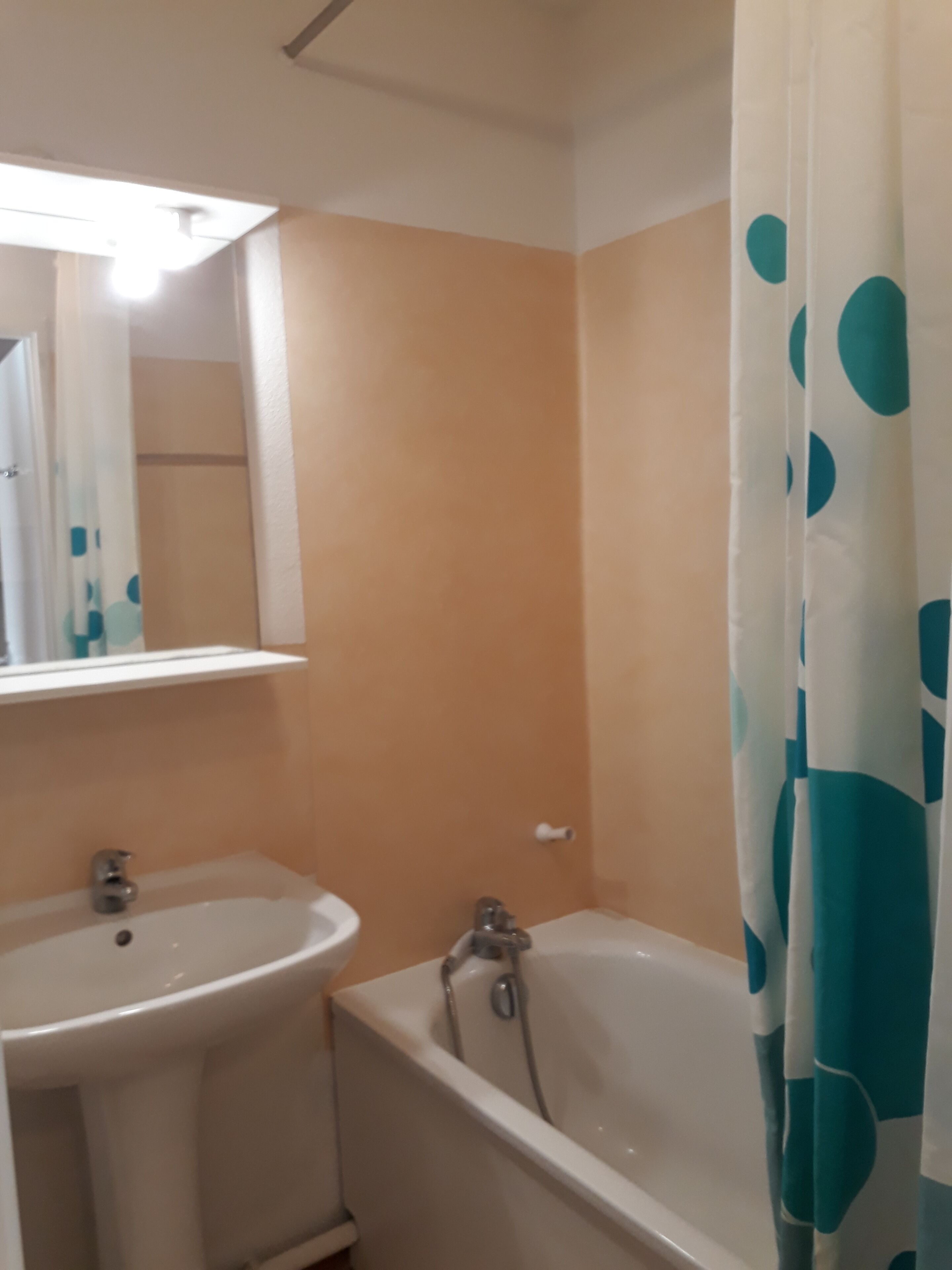A bathroom with a sink, mirror, and bathtub.