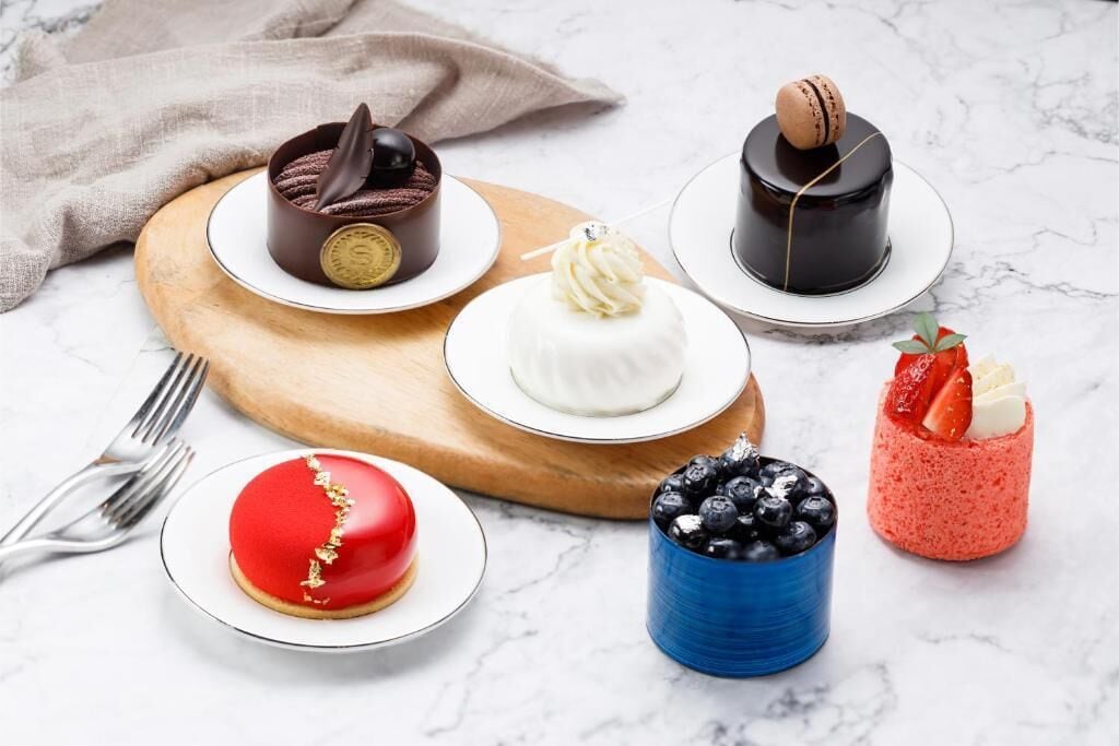 Verschillende desserts op borden en een blauwe mok met bosbessen.