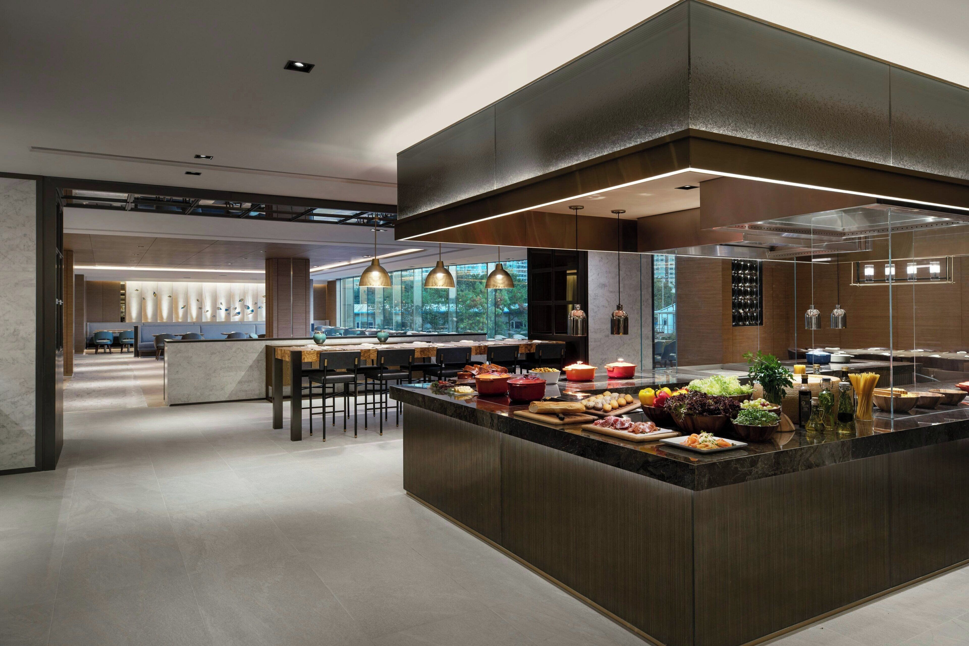 A modern kitchen with a central island, bar seating, and pendant lighting.