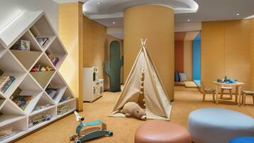 Children can play and learn in this inviting space with a teepee tent, books, and a scooter.