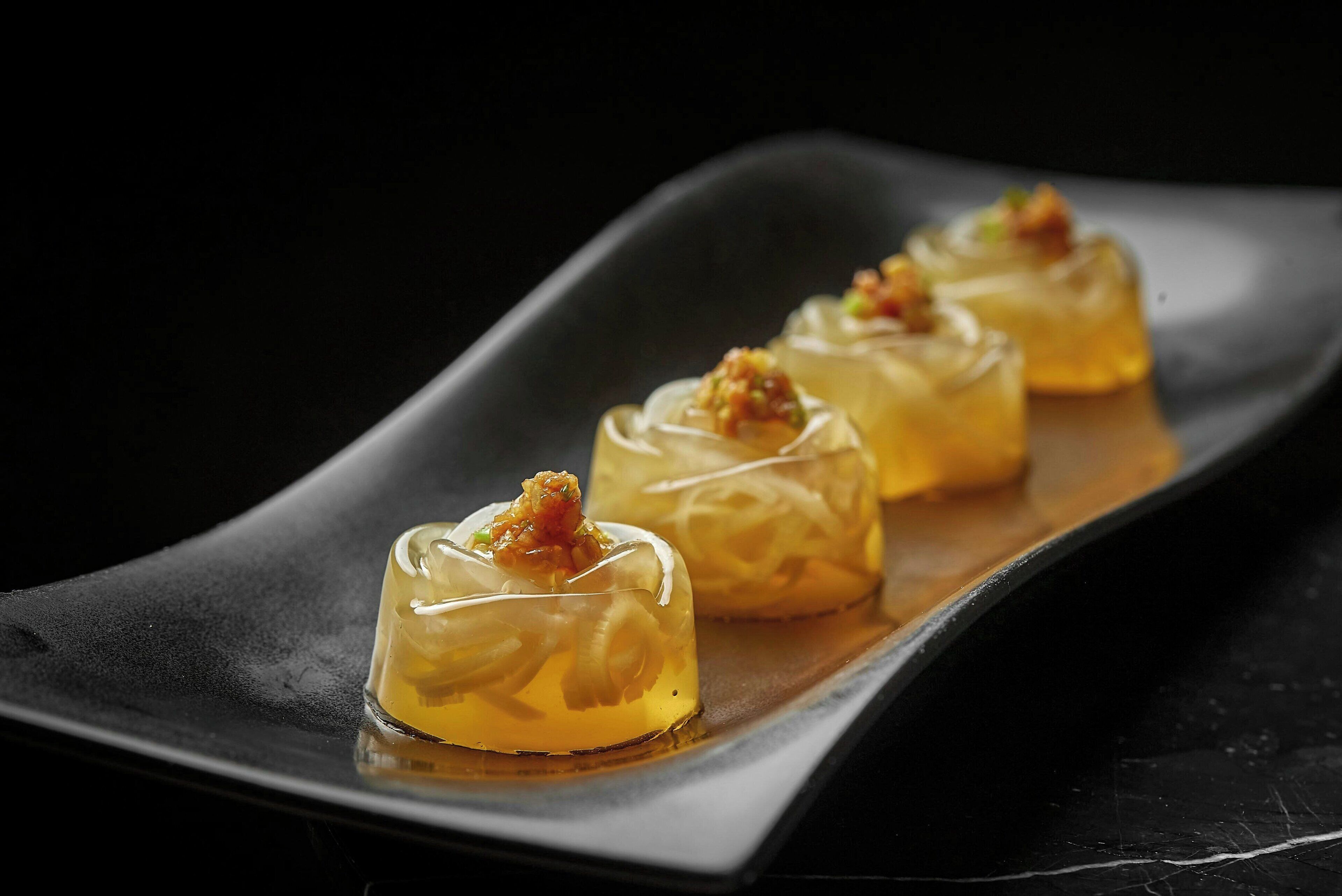 Drie transparante dessertglazen op een zwart bord.