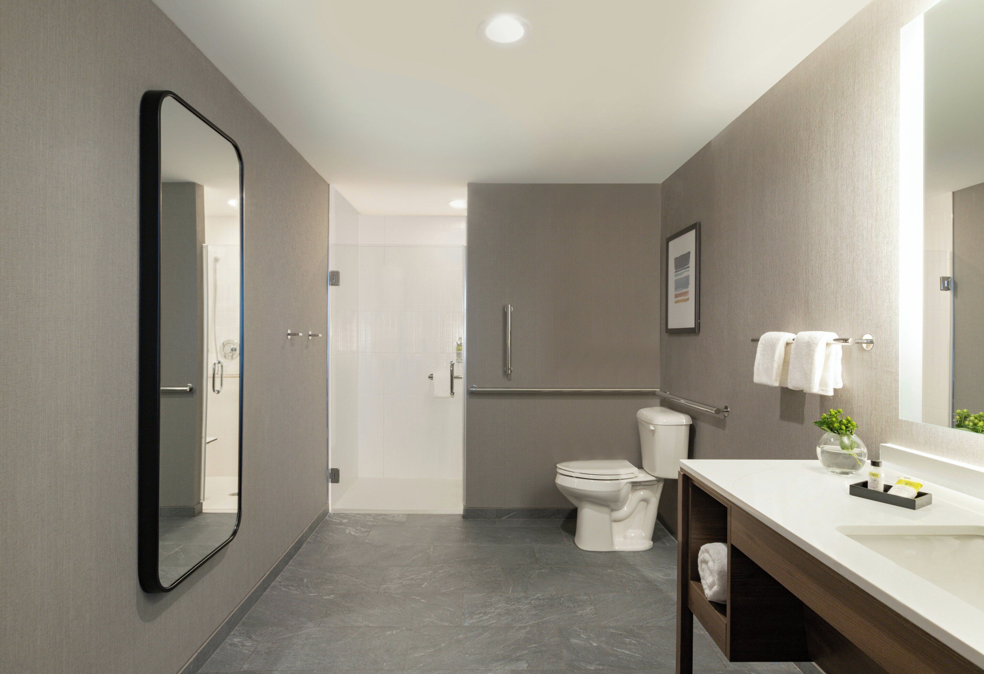 Et moderne badeværelse med toilet, håndvask og spejl.