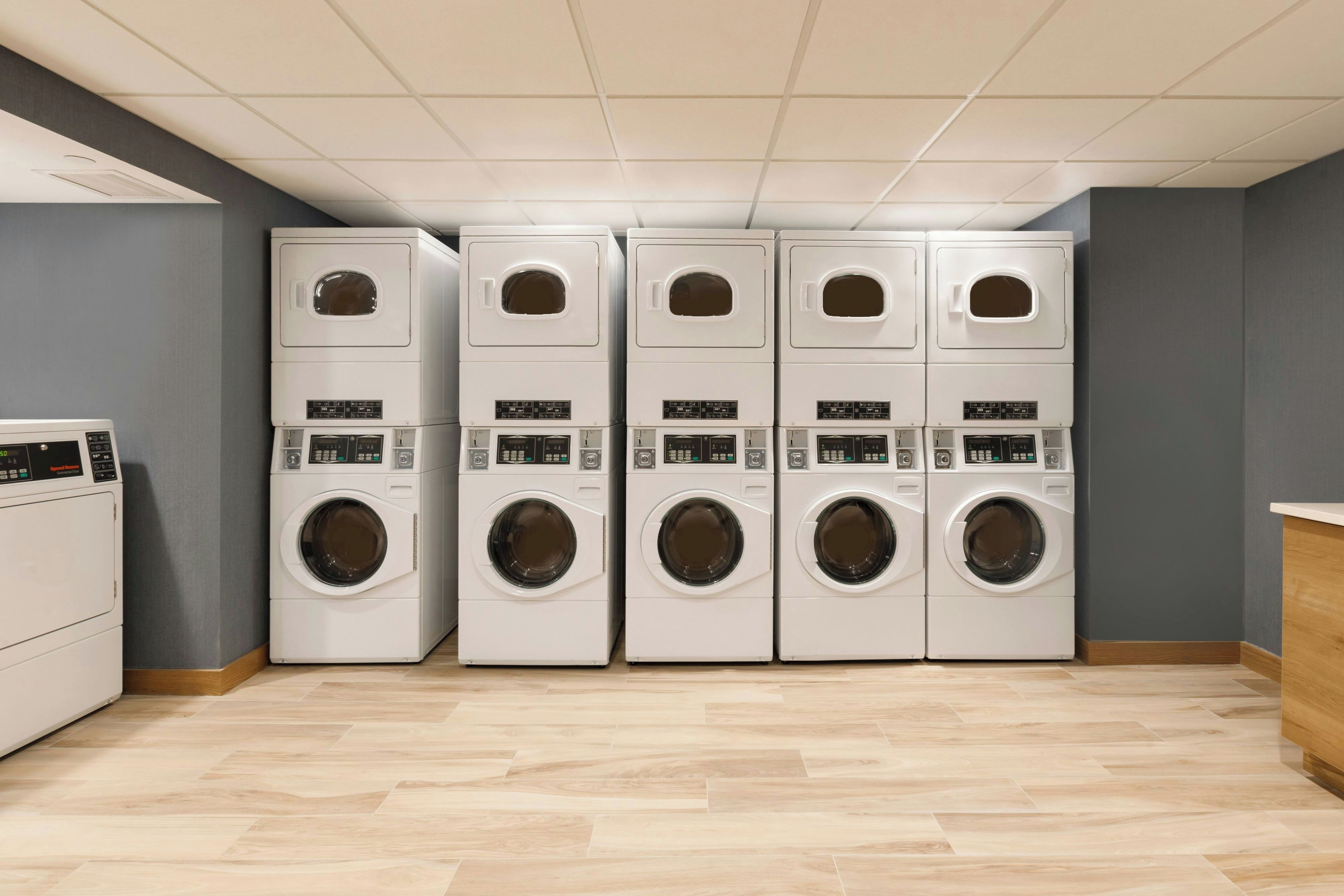 A laundry room with four stacked washing machines and a dryer.
