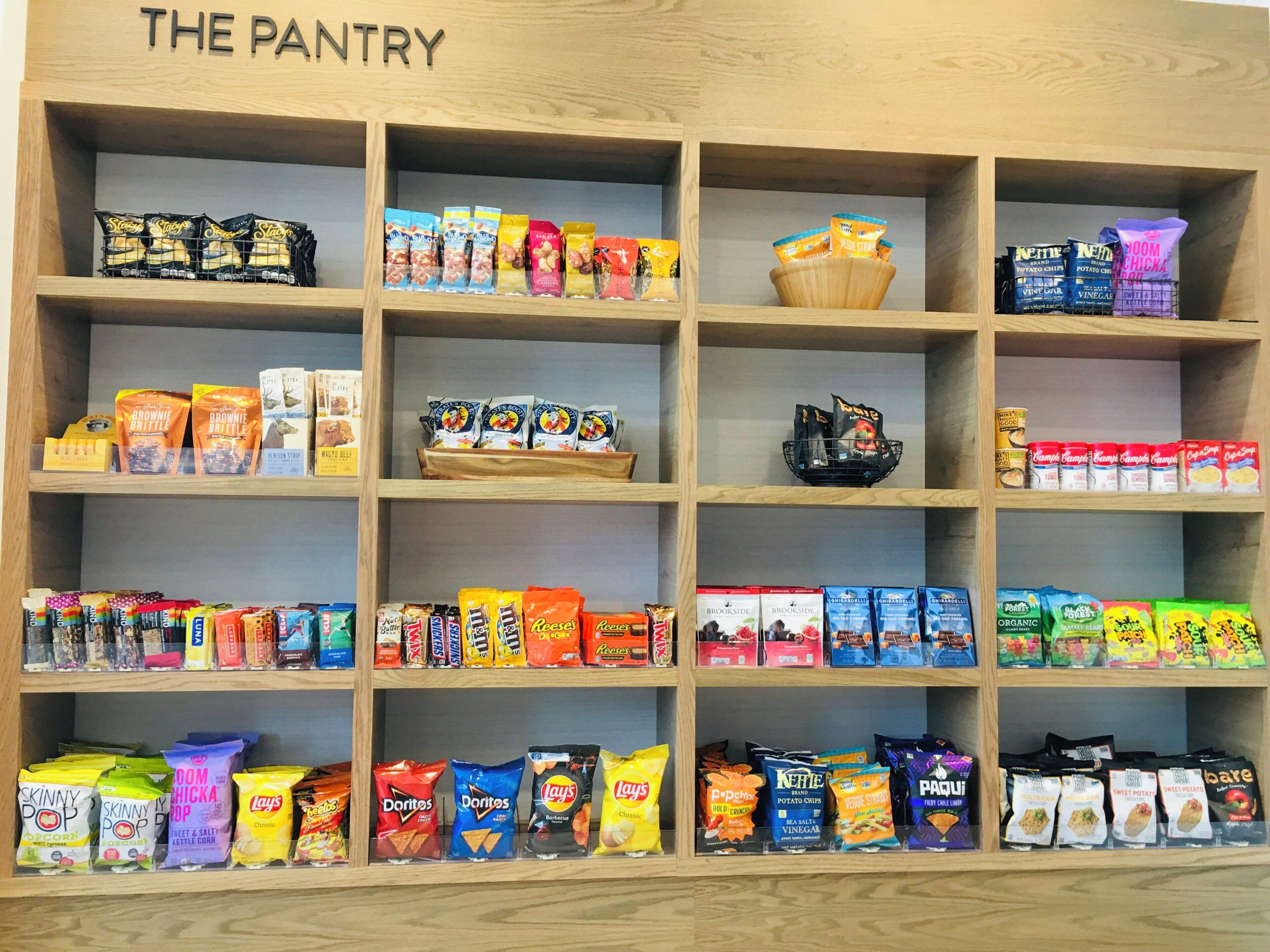 A pantry with various snacks and food items organized on shelves.