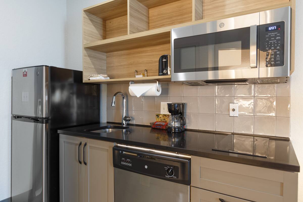 A modern kitchen with stainless steel appliances, a dishwasher, and a microwave.