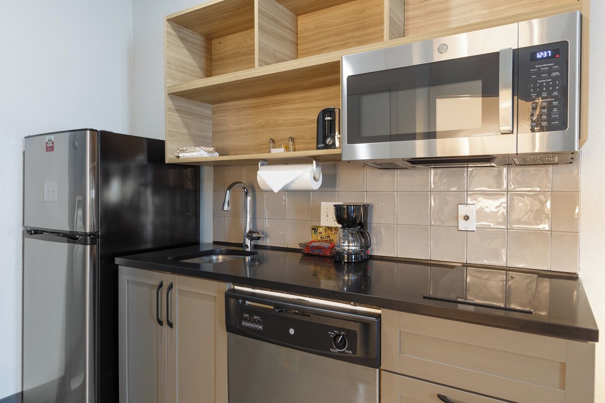 A modern kitchen with stainless steel appliances, a dishwasher, and a microwave.