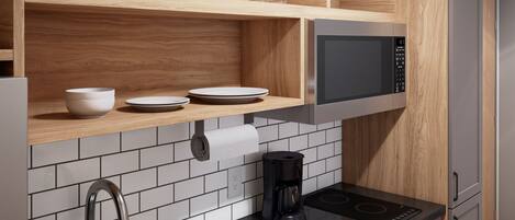 A modern kitchen with a built-in microwave, a coffee maker, and a sink with a faucet.