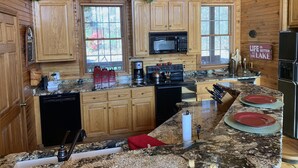 A kitchen with wooden cabinets, a microwave, a stove, and a refrigerator.
