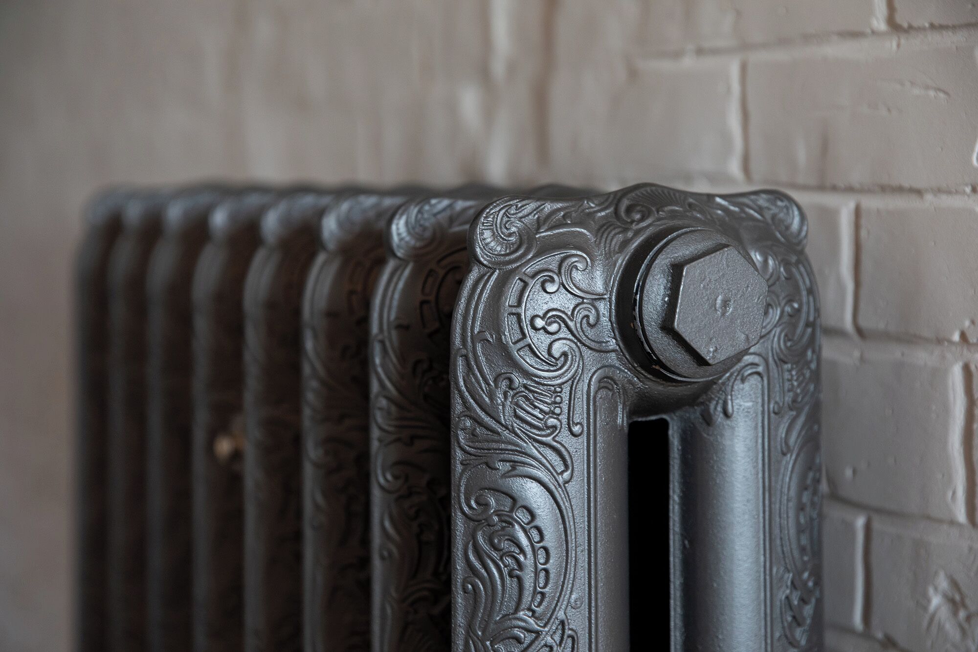 Een detailopname van een radiator met ingewikkelde versieringen.