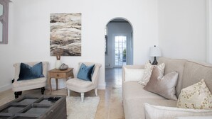 A living room with a beige sofa, two armchairs, a coffee table, and a painting on the wall. - Beautiful Iconic Listed Building with Views Overlooking the Arundel Cathedral (Arundel)