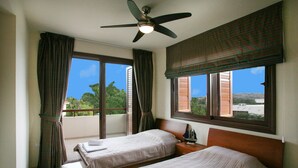 A hotel room with two beds, a ceiling fan, and large windows with curtains. -  An outstanding luxury and comfort property  located in a quiet luxury complex  (Protaras - Ammochostos)