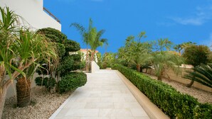 A pathway leading to a building with a white exterior and a red-tiled roof. -  An outstanding luxury and comfort property  located in a quiet luxury complex  (Protaras - Ammochostos)