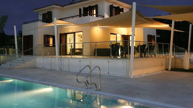 A modern two-story house with a swimming pool, outdoor seating, and a covered patio area. -  An outstanding luxury and comfort property  located in a quiet luxury complex  (Protaras - Ammochostos)