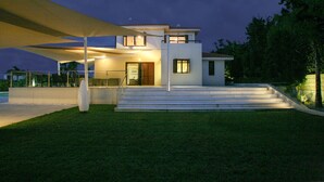 A modern two-story house with a covered outdoor area, steps leading to the entrance, and a well-maintained lawn. -  An outstanding luxury and comfort property  located in a quiet luxury complex  (Protaras - Ammochostos)