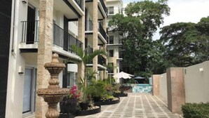 Une cour avec une fontaine, des plantes en pot et un espace piscine.