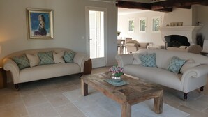 Sala de estar com dois sofás, uma mesa de centro e uma lareira.