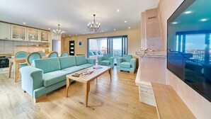A modern living room with a sofa, chairs, a coffee table, and a TV. - Luxury Villa Indigo with Pool (Split)