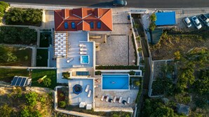An aerial view of a modern house with a swimming pool, outdoor seating, and solar panels. - Luxury Villa Indigo with Pool (Split)