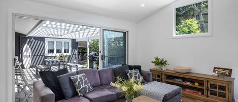 Un salon moderne avec un canapé gris, une table basse et un meuble en bois.