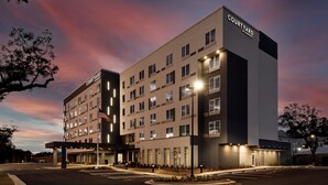 A Courtyard by Marriott hotel with a modern design, multiple floors, and a well-lit entrance.