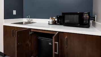 Cocina compacta equipada con microondas, lavaplatos y refrigerador.