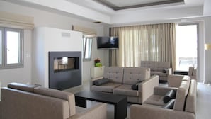 Una sala de estar moderna con chimenea, televisor de pantalla plana y varias zonas de estar.