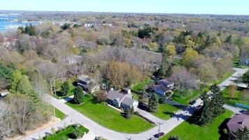 An aerial view of a residential area with houses, roads, and a river in the background.