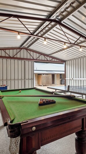 A billiards table with a green felt surface, a set of balls, and a cue stick. - Prowse Beach House—Family Fun & Ocean Adventures (Dunsborough)