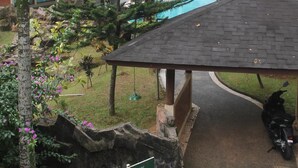 A pool area with a covered seating area, a visible pool, and a sign indicating a pool view. - New Green Sentul Resort (Sentul City)