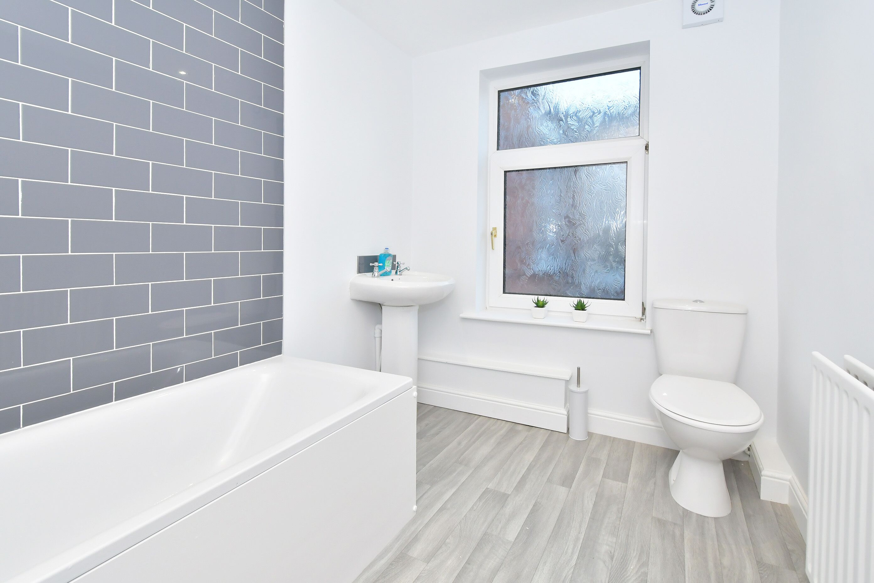 A bathroom with a white bathtub, a white sink, and a toilet.