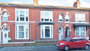A row of red brick terraced houses with white-framed windows and a red car parked in front. - Townhouse @ 272 Walthall Street Crewe (Crewe)