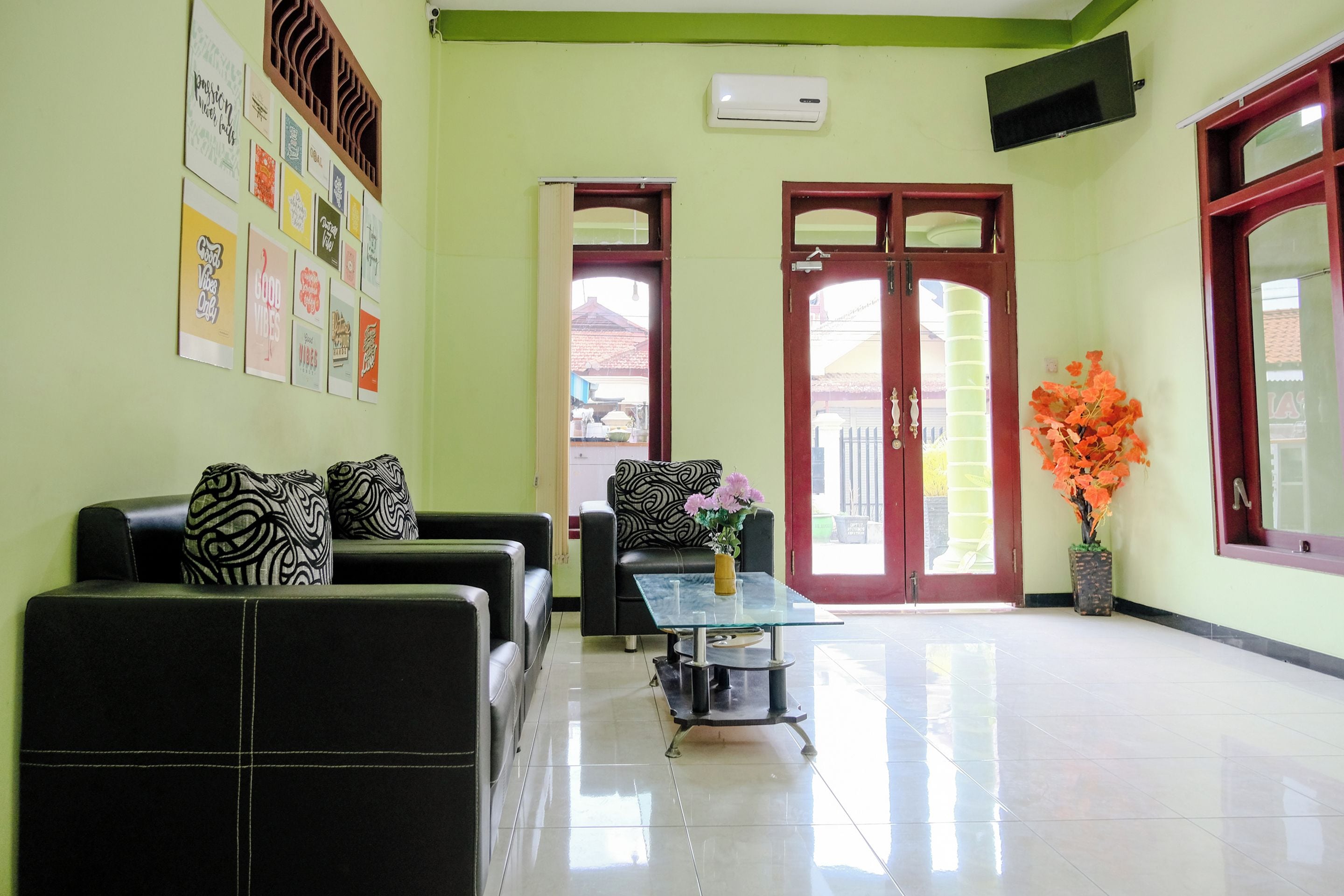 A reception area with a sofa, a coffee table, and a vase of flowers.