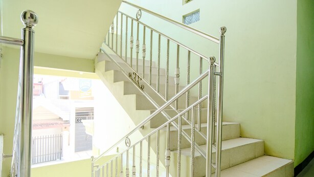 A staircase with metal railings and beige steps. - Oyo 2508 Alba Suites Homestay (Tulungagung)