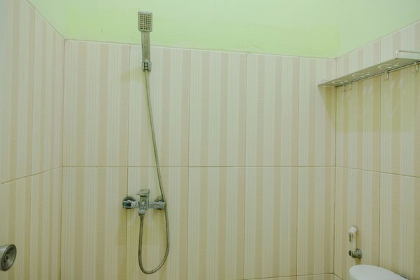 A bathroom with a shower, a toilet, and a towel rack.