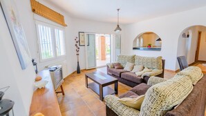 A living room with a sofa set, a coffee table, and a television. - Villa Soleada Algarrobo by Ruralidays (Málaga)