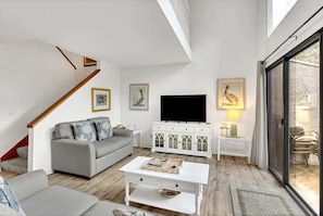 A modern living room with a grey sofa, white coffee table, and a flat-screen TV. - Beachside Hilton Head Villa with Pool, Tennis (Hilton Head Island)