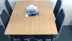 A wooden table with a remote control and tissues on it. - Ulster Apartments (Hamilton)