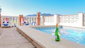A poolside area with lounge chairs, a bottle of champagne, and glasses on the edge of the pool. - Caballo Blanco Coín by Ruralidays (Málaga)