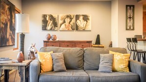 A living room with a grey sofa, wooden coffee table, and artwork on the wall. - Telluride - 1 Bedroom with Forest View (Telluride)