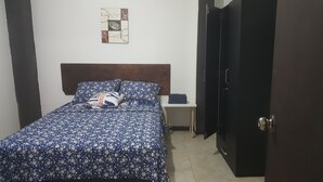 Una camera da letto con un letto, un comodino, un armadio e un quadro appeso al muro.