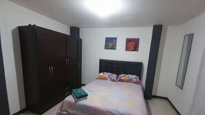 Una camera da letto con un letto, un armadio e due opere d'arte a parete.