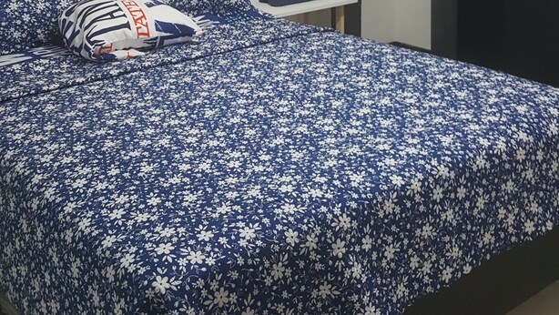 Una camera da letto con un letto, una sedia, un armadio e un quadro appeso al muro.
