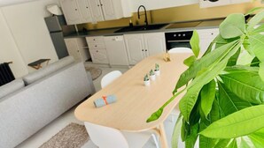 Une cuisine moderne avec des meubles blancs, un plan de travail noir et un évier.