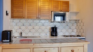 A kitchen with wooden cabinets, a microwave, a coffee maker, and a toaster.