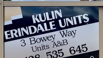 Placa indicando Kulin Erindale Units, com o endereço, número de contato e ícones de redes sociais.