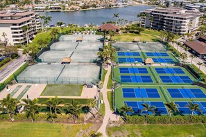 A tennis court complex with multiple courts, a pool, and surrounding greenery. - Sunsets and Endless Ocean Views, Beach Front Condo. Seaview Tower 3 #711 (Marco Island)