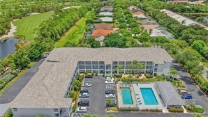 Vista aérea de un hotel con piscina, aparcamiento y zonas verdes circundantes.