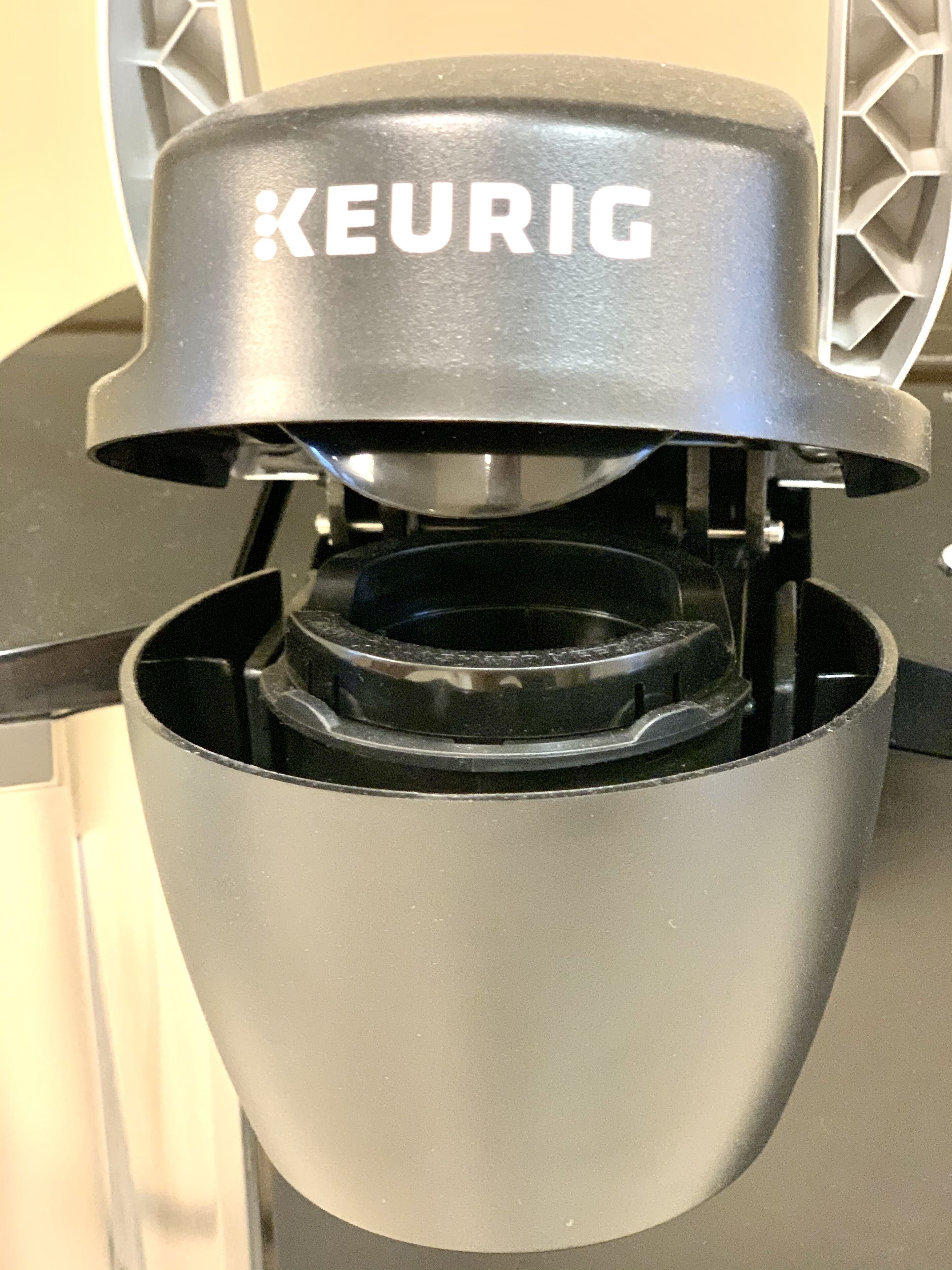 Une machine à café Keurig dotée d’un bac de récupération et d’un support pour les dosettes de café.