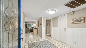 A hallway with a patterned rug, a sign indicating a beach direction, and a door with a blue frame. - Light, Bright and Airy condo at Amelia Island Plantation (Fernandina Beach)